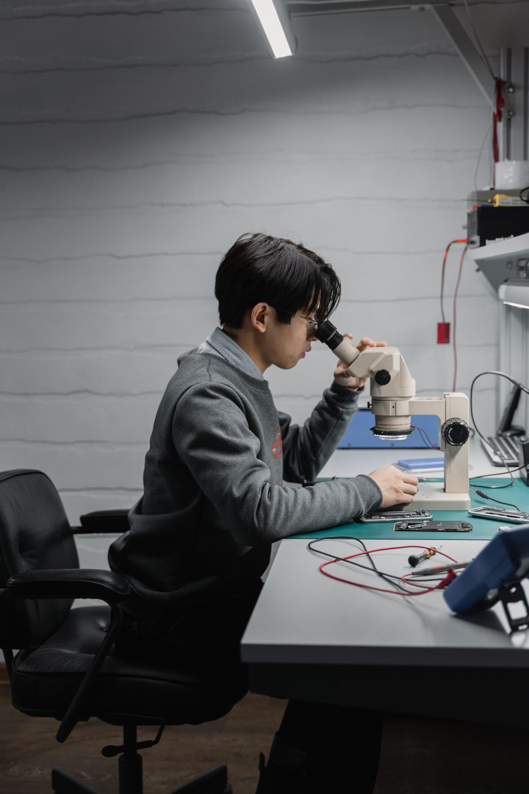 Engineer inspecting electronic components with a microscope
